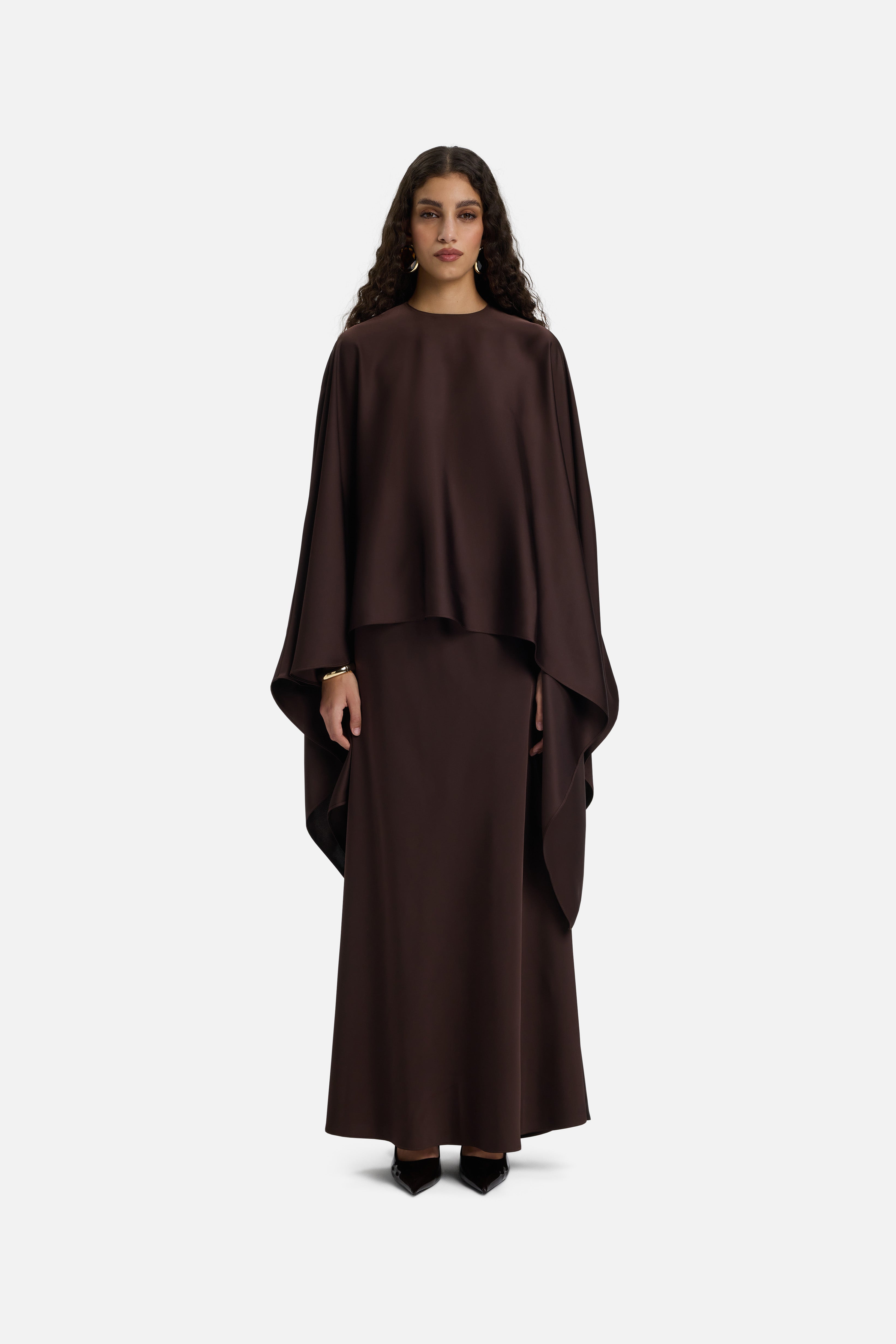 Front view of model wearing dark brown asymmetric blouse