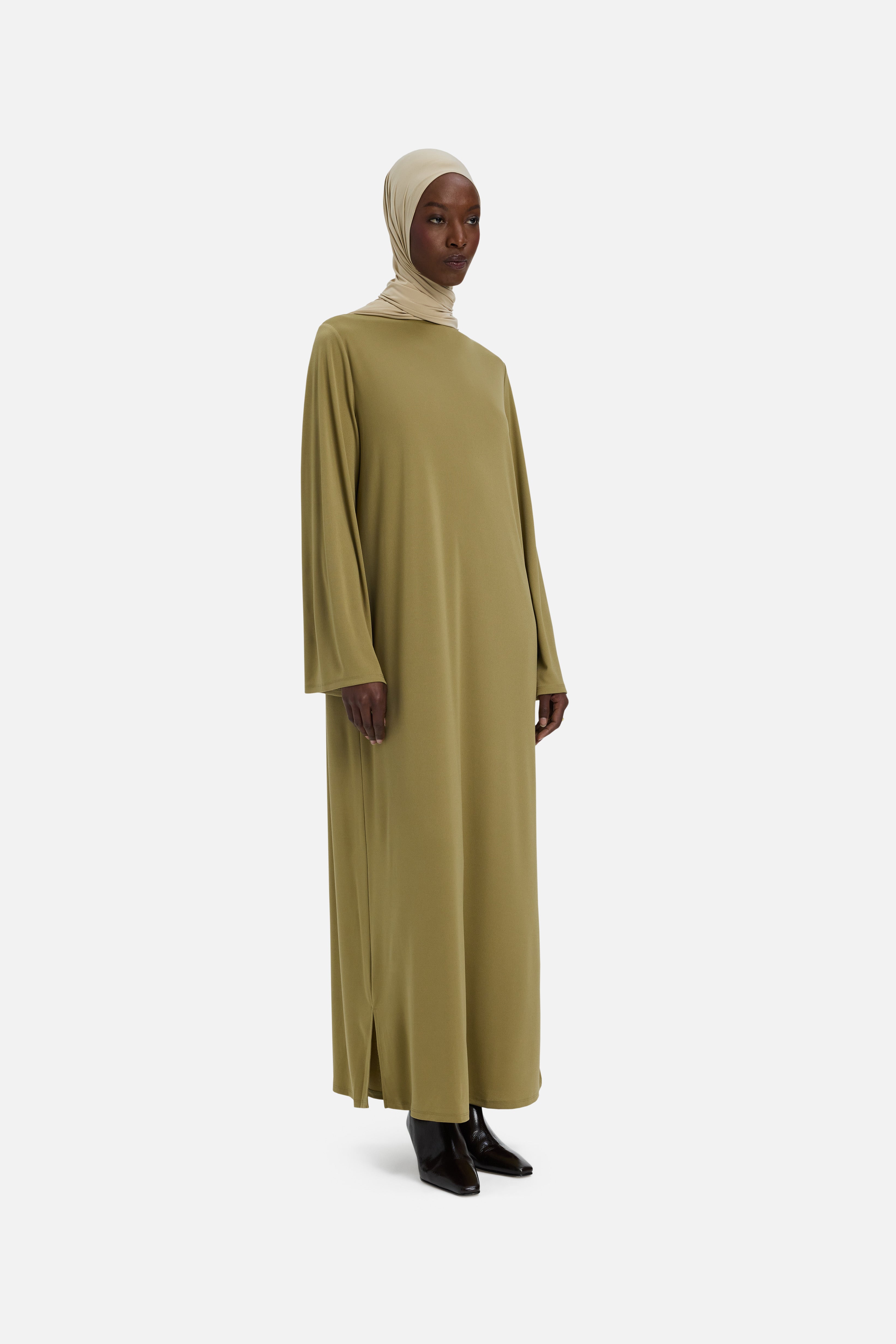Side view model wearing green dress and headscarf