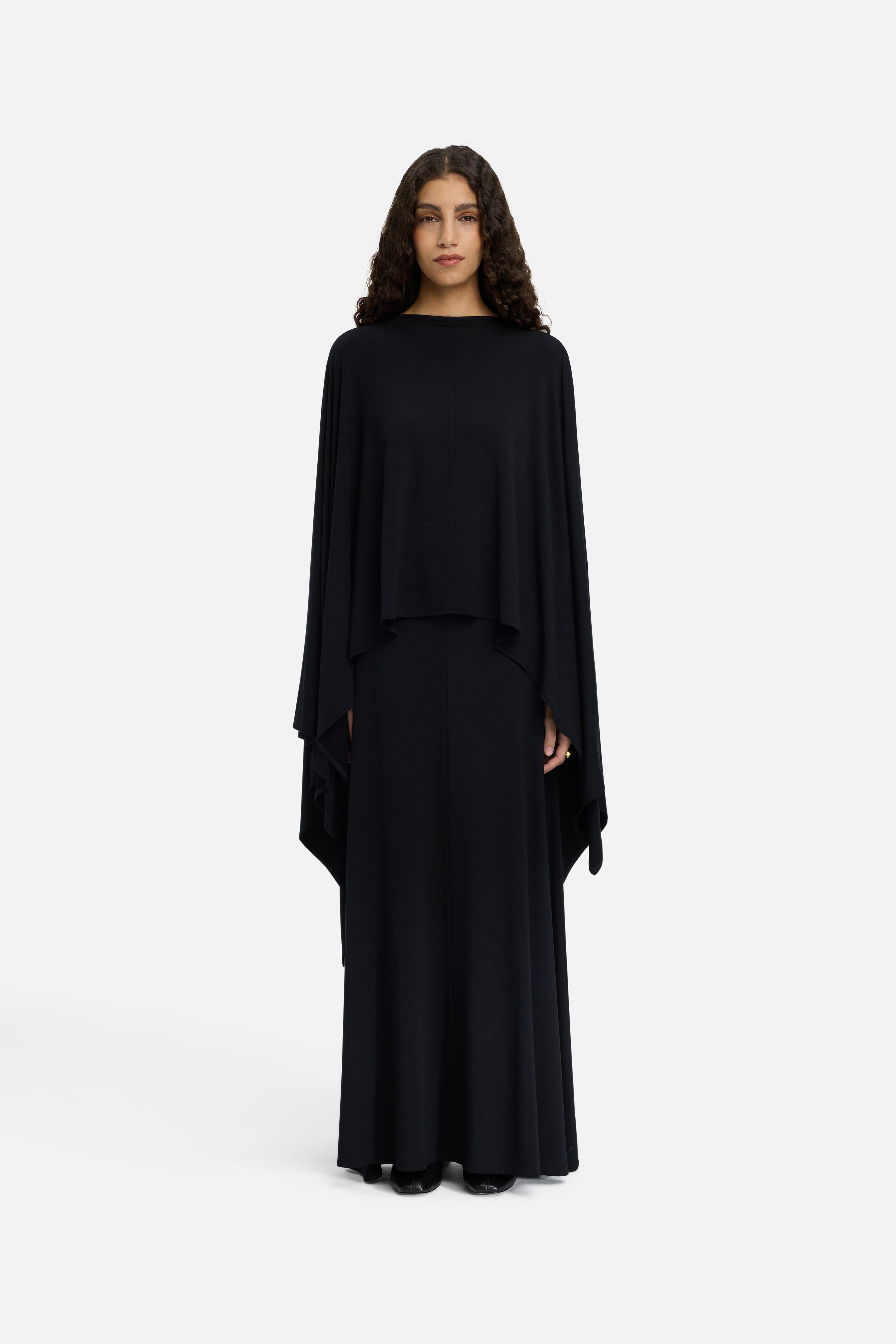 Model wearing black MERRACHI cape, front view
