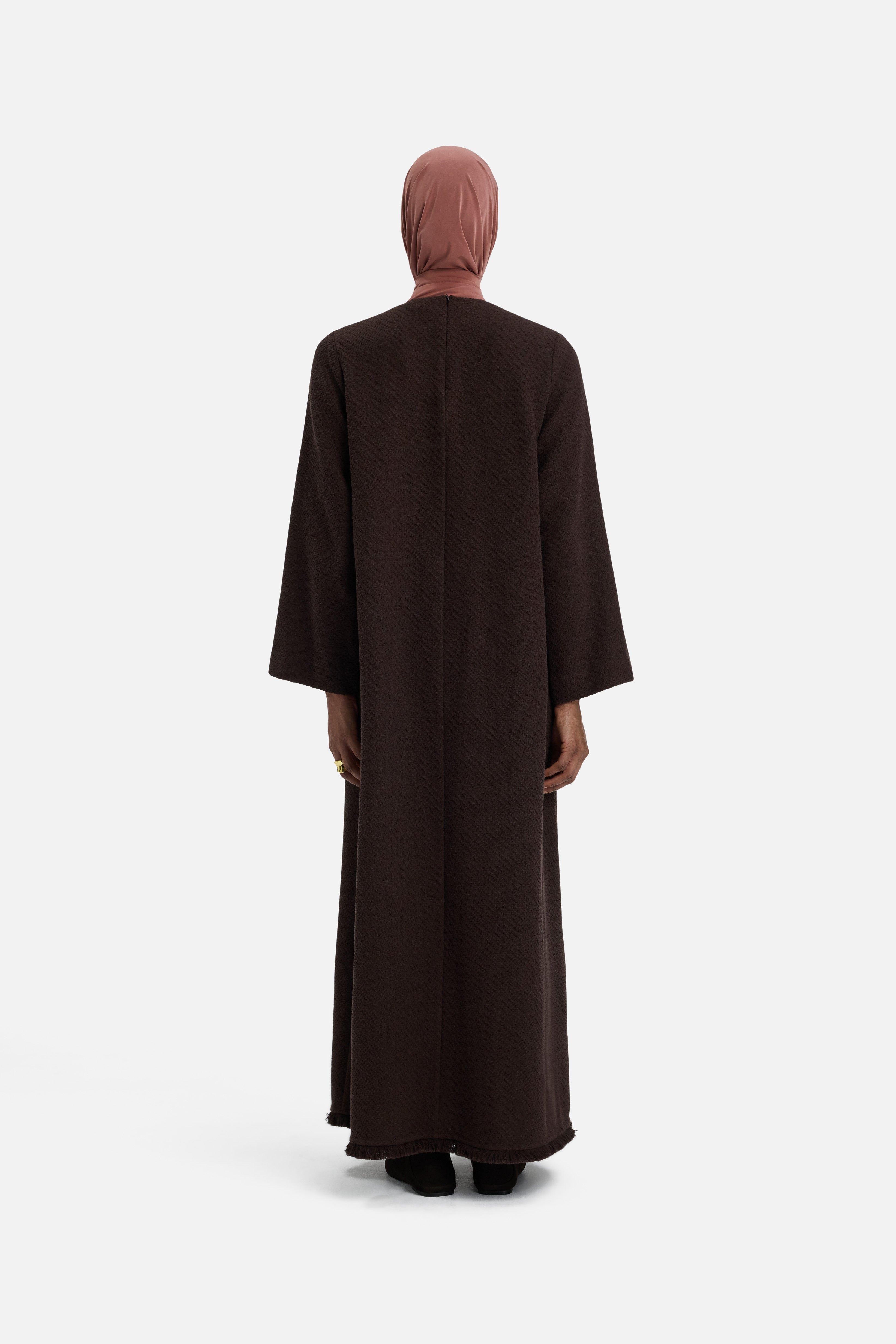 Back view model wearing dark brown dress and pink head scarf