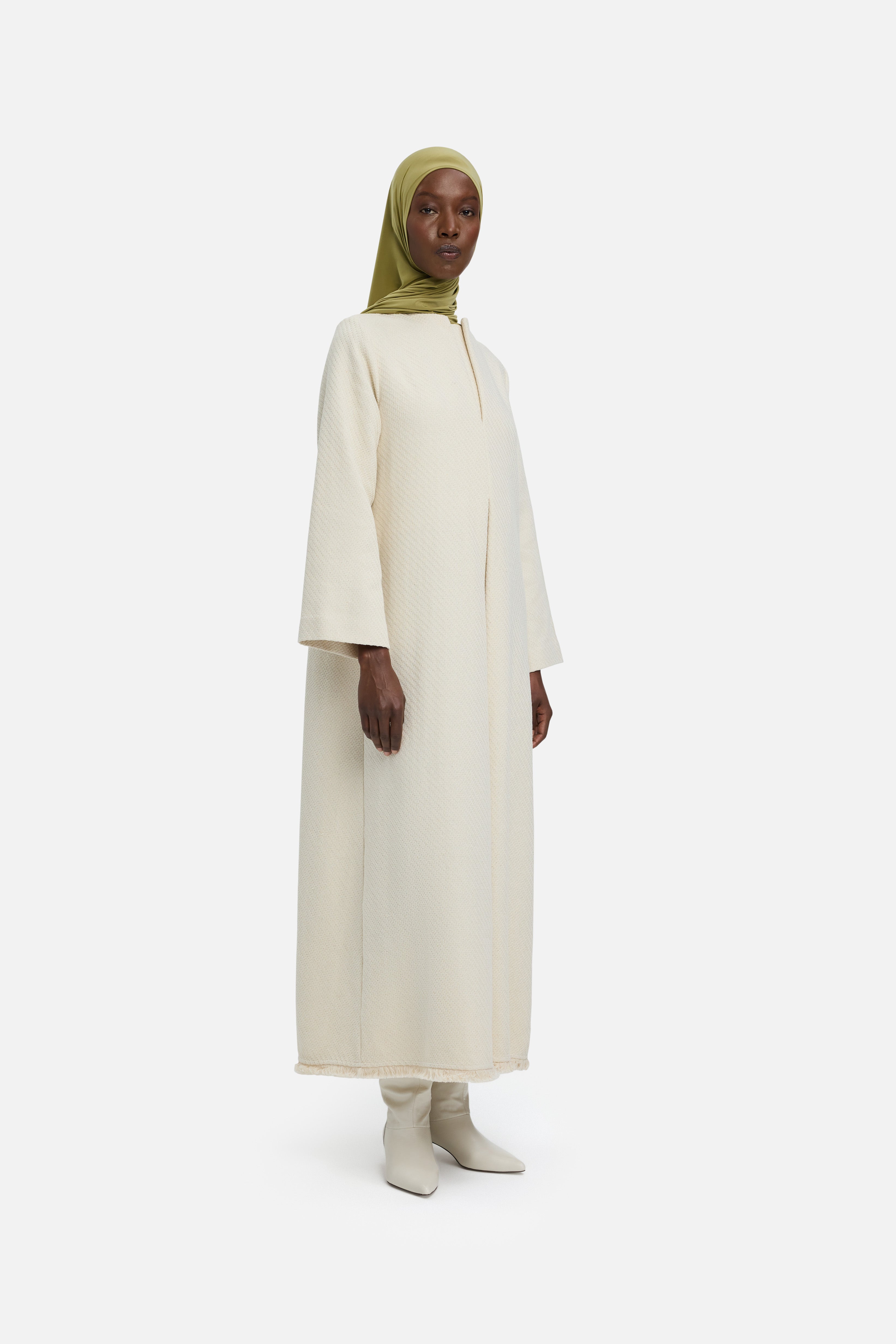 Side view model wearing off white dress and green headscarf