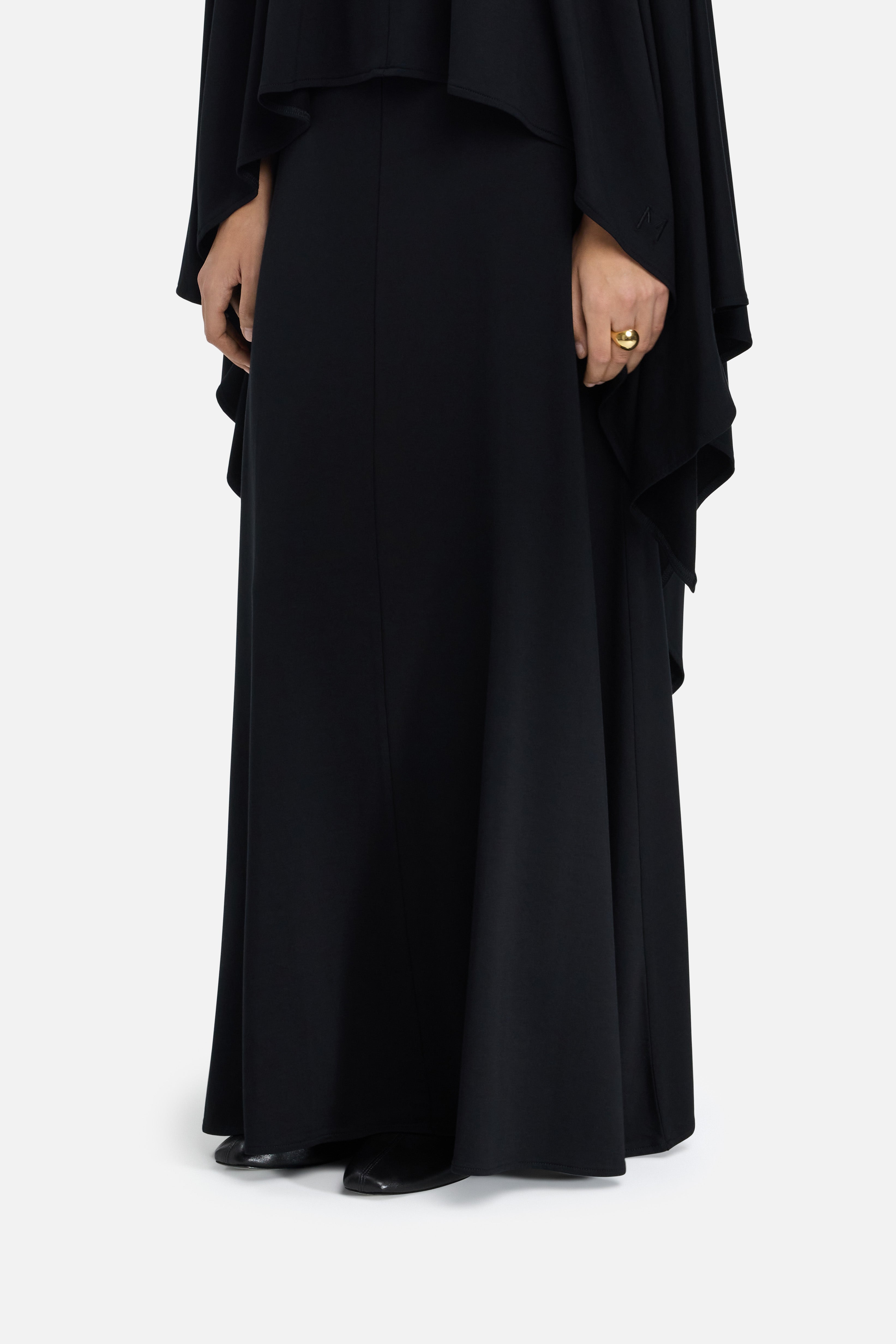 Cropped side view model wearing black maxi skirt