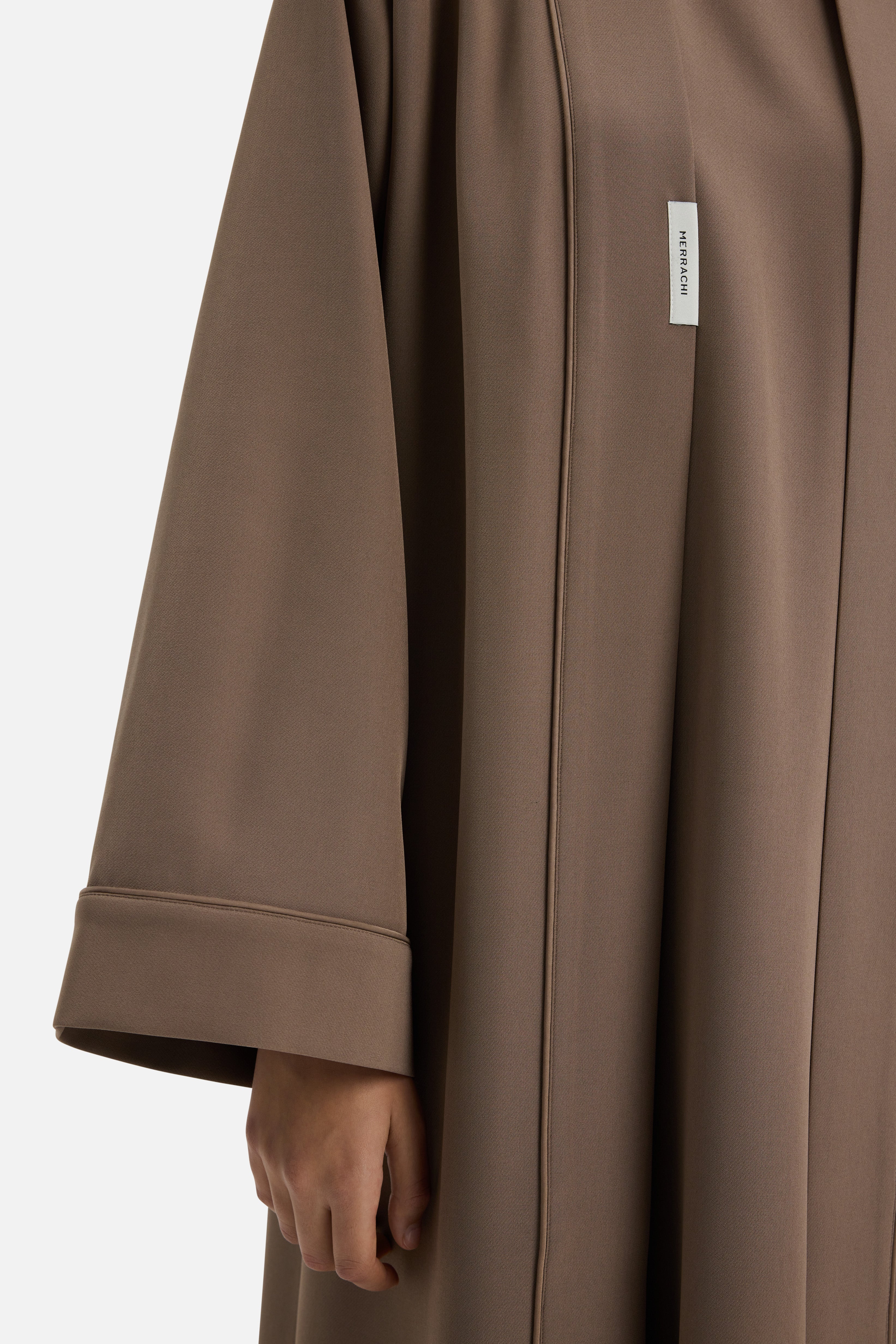 Detail shot taupe abaya with MERRACHI logo