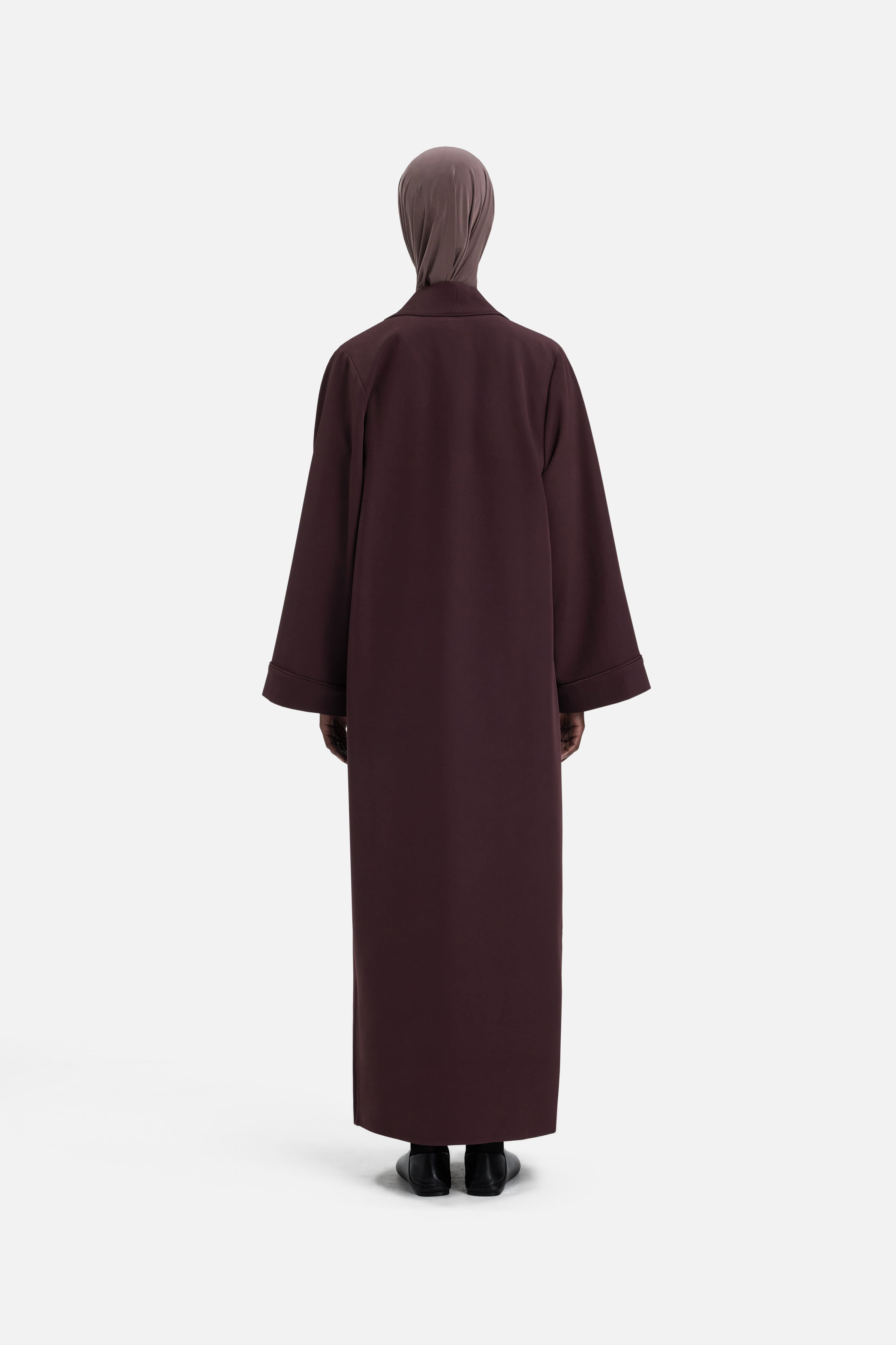Model wearing purple abaya and headscarf, back view