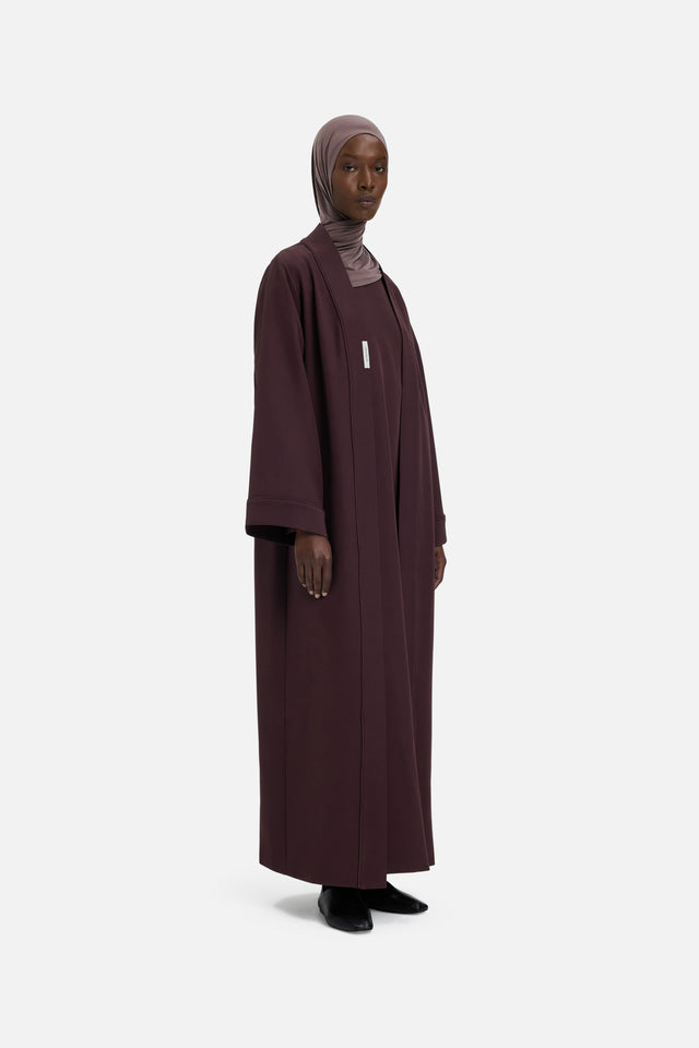 Model wearing purple abaya and headscarf, front view