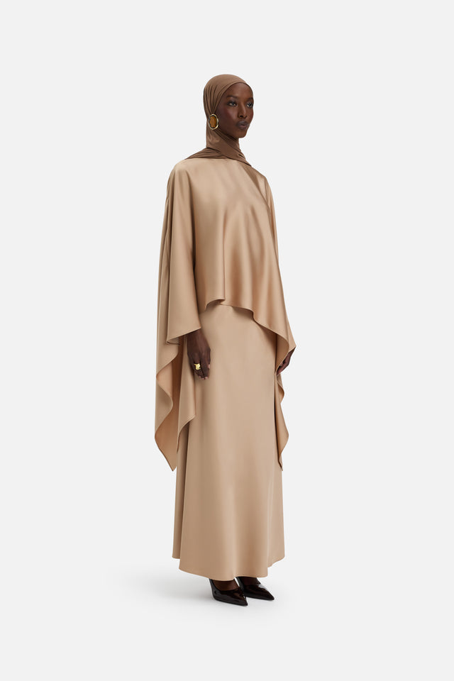 Front view of model wearing light brown asymmetric blouse
