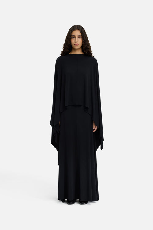 Model wearing black MERRACHI cape, front view