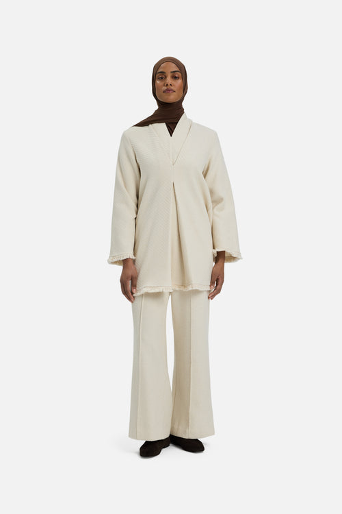 Front view model wearing white trousers and brown headscarf