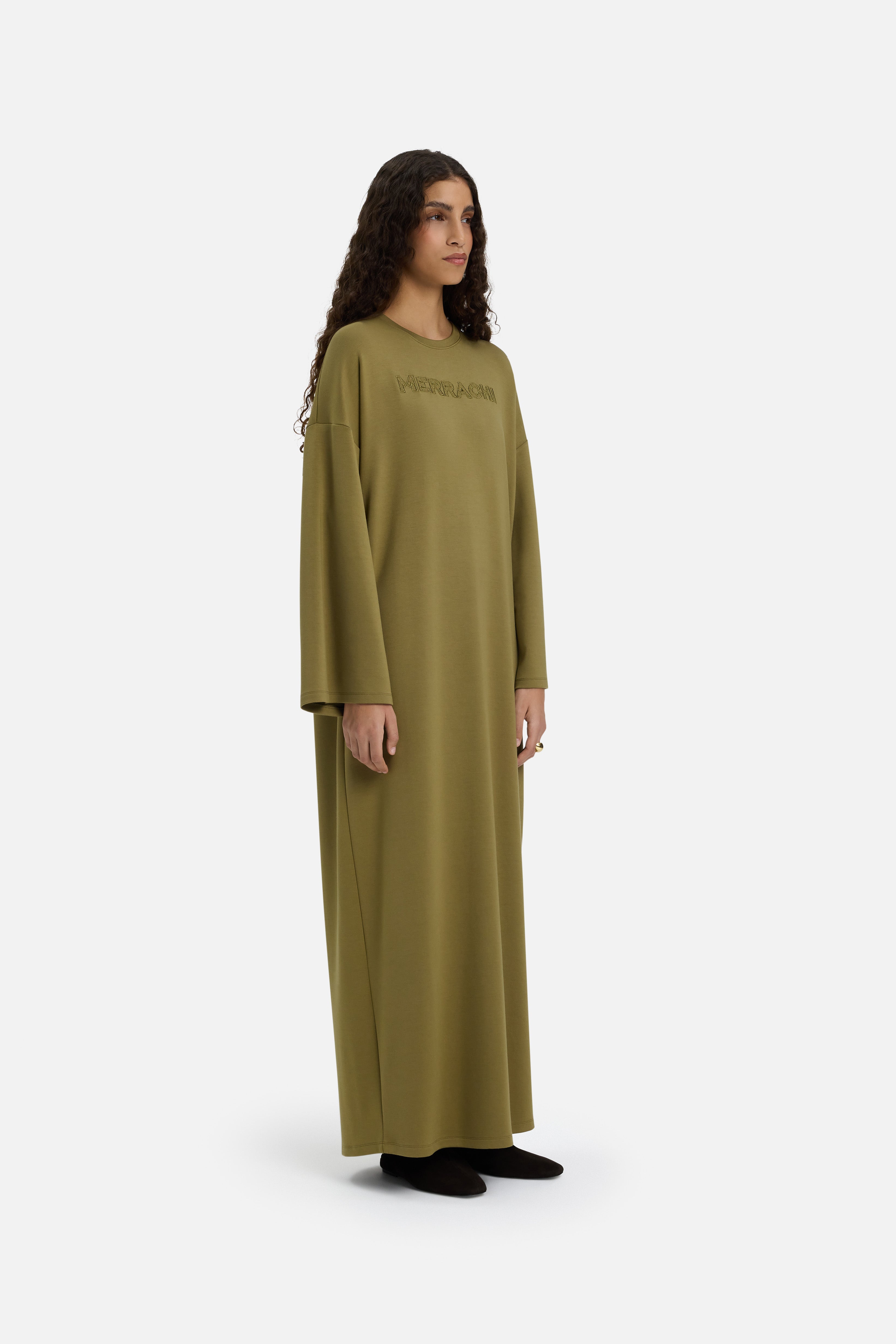 Model wearing green MERRACHI dress, side view