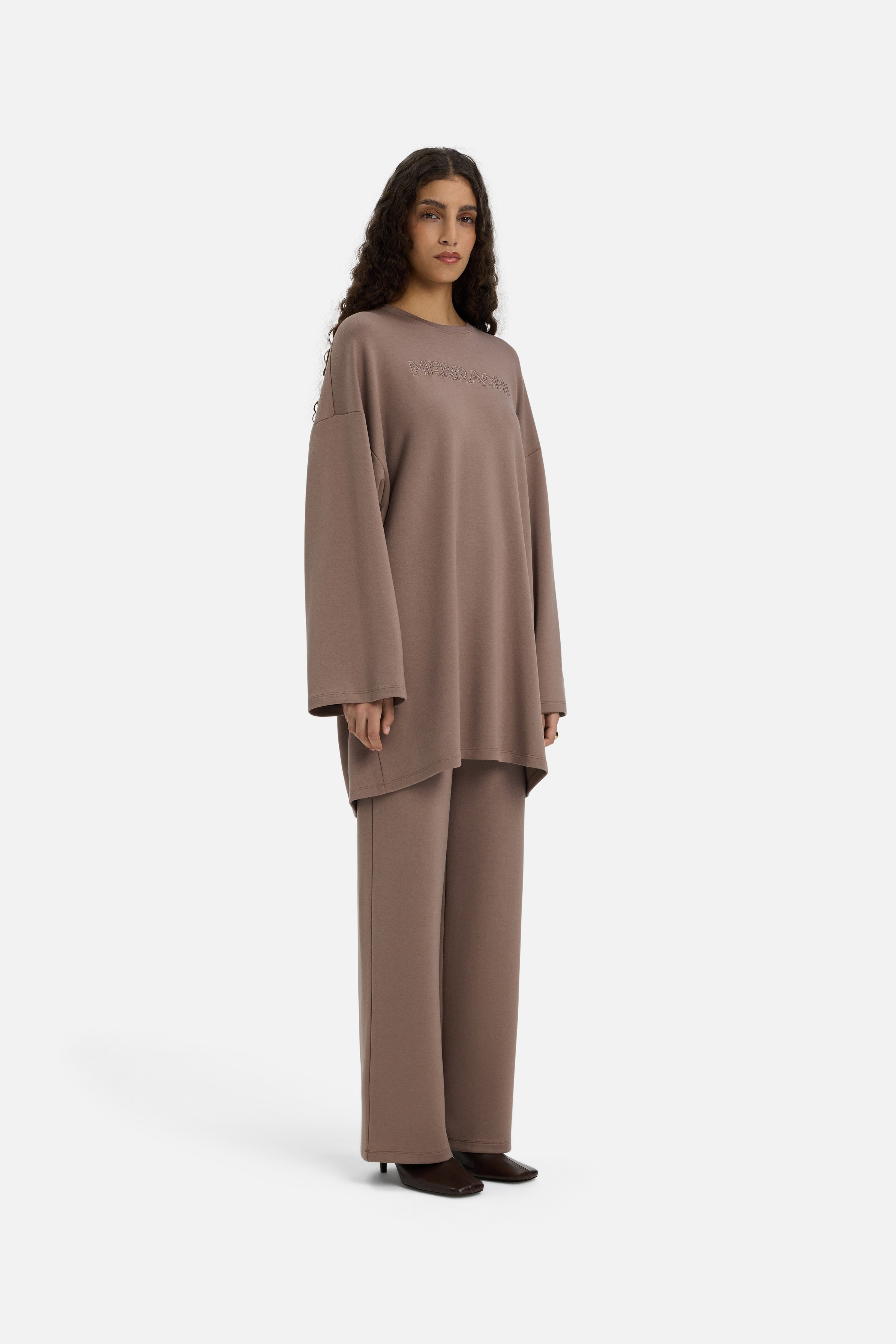 Model wearing taupe MERRACHI pants, side view