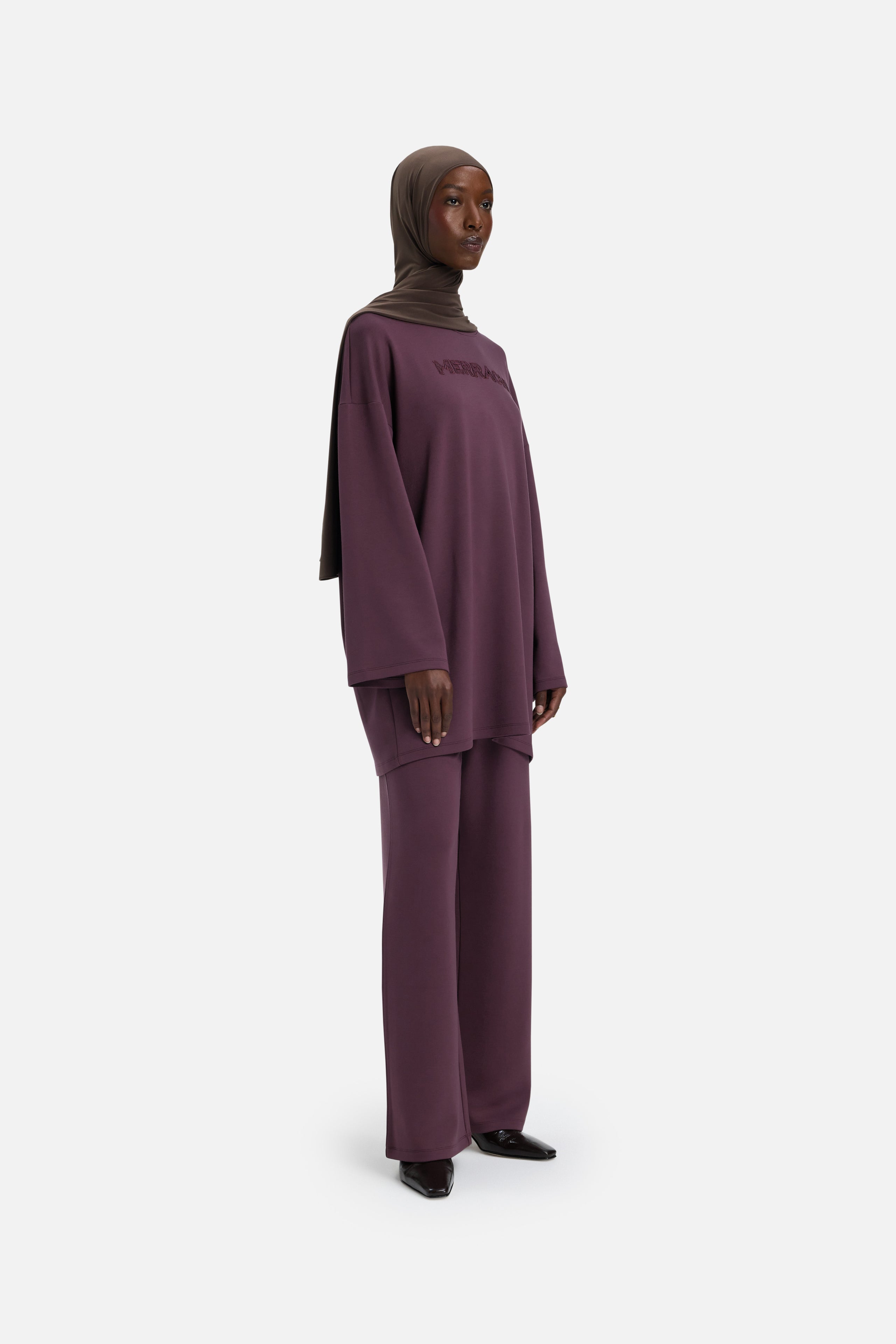 Model wearing purple MERRACHI pants, front view